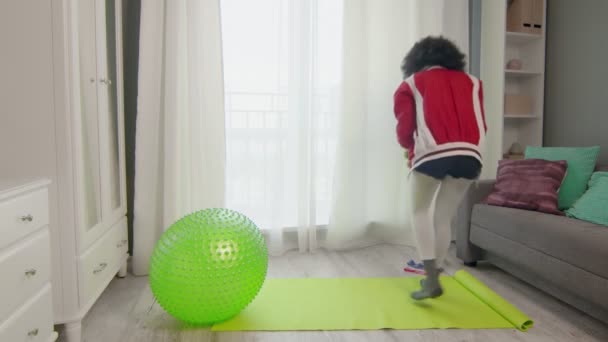 Fiatal afro-amerikai nő hippi színes sportruházat göndör afro szőrszálak készíti a sport eszközöket, hogy dolgozzanak ki otthon. — Stock videók