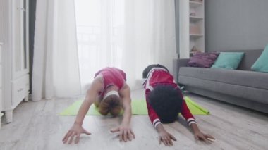 Komik eski tarz birkaç beyaz erkek ve afro kadın evde çocuk yoga pozu veriyorlar.