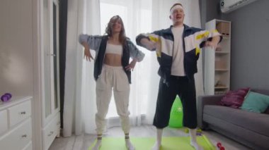 Mutlu, genç ve sağlıklı çift evde çalışıyor. Esneme egzersizi yapıyorlar.