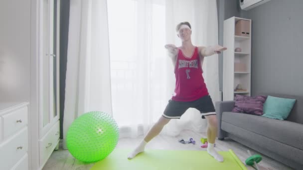 Retro stylowy młody człowiek robi dacnes aerobik ćwiczenia w domu — Wideo stockowe