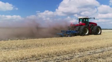 Kırmızı bir traktördeki çiftçi tozlu çorak toprağı sürüyor. Çiftlik arabası aç kuşlar tarafından takip edilir. Baharda tarım işi