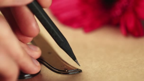 Primer plano del hombre utiliza lápiz y la curva francesa Regla métrica para pintar en papel kraft — Vídeos de Stock