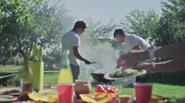 Genç arkadaşlar dışarıda bbq partisi hazırlıyorlar.