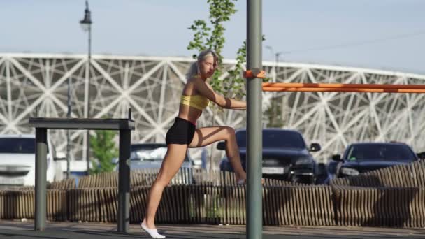 Side view of athletic woman is stretches and sits on the twine — Stock Footage Side view of athletic woman is stretches and sits on the twine Royalty Free Stock Footage