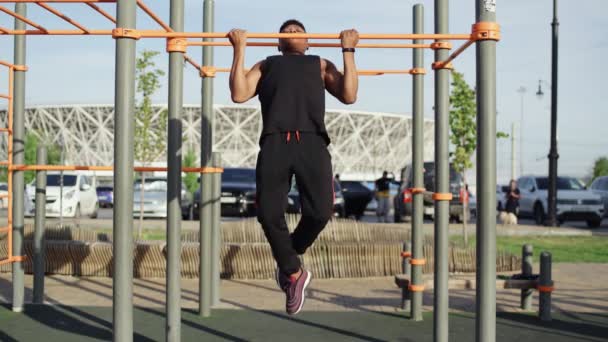 Afro homem fazendo pull ups no horizontal treino ao ar livre — Vídeo de Stock