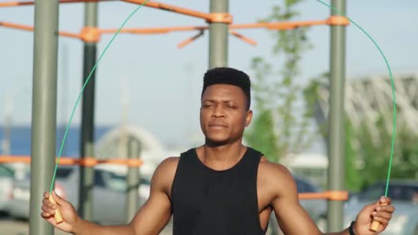 Bonito desportivo afro homem exercitando com corda de salto ao ar livre — Vídeo de Stock