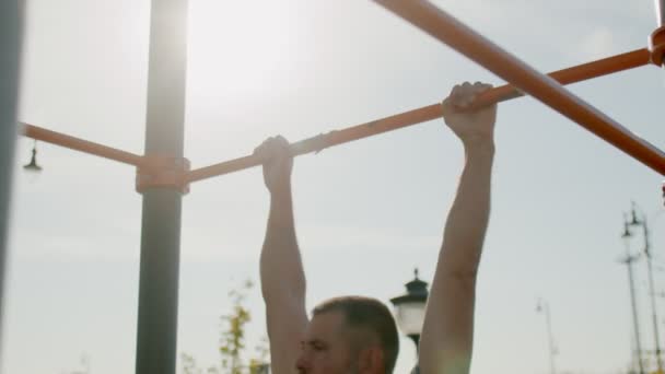 Homme sportif senior accroché à une barre horizontale et lève les jambes — Video