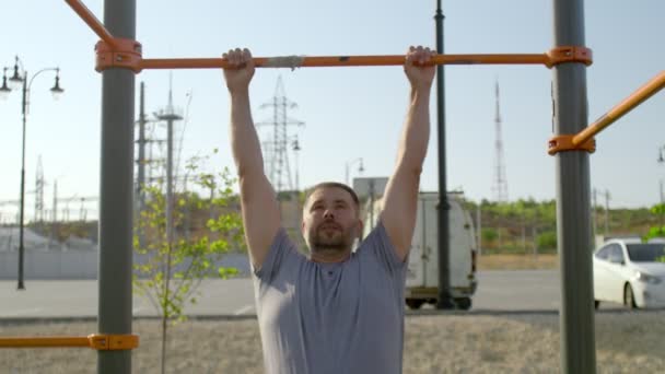Senior sporty man hangs on a horizontal bar and raises his legs — Stock Footage Senior sporty man hangs on a horizontal bar and raises his legs Stock Video