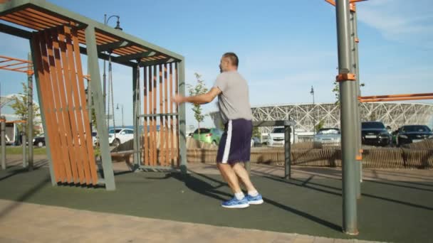 Старший спортивний чоловік займається з мотузкою на відкритому повітрі — стокове відео