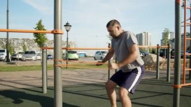 Kıdemli kaslı adam dışarıda elastik bantla egzersiz yapıyor. Egzersiz