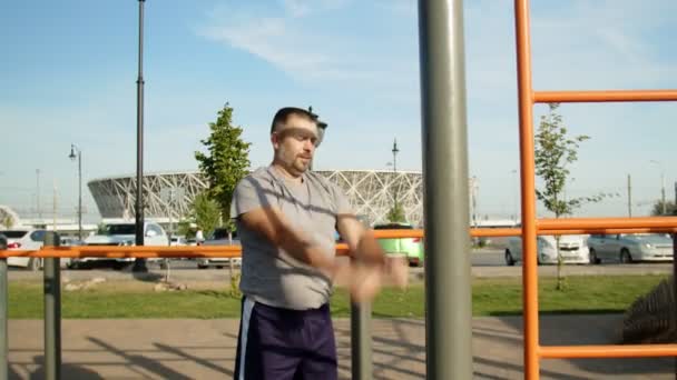 Homem sênior em camiseta cinza girando as mãos para aquecer ao ar livre — Vídeo de Stock
