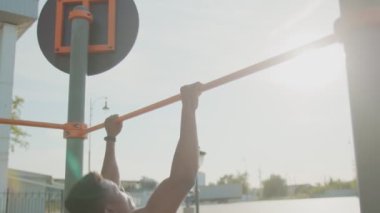 Afrikalı bir adamın yatay antremanda barfiks çekerken görüntüsü.