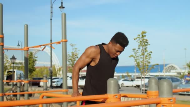 若いアフリカ人が市内公園の水平なバーで. — ストック動画