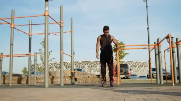 Deportes de fitness hombre africano haciendo ejercicio con goma elástica — Vídeo de stock