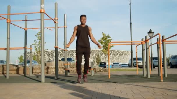 Bonito desportivo afro homem exercitando com corda de salto ao ar livre — Vídeo de Stock