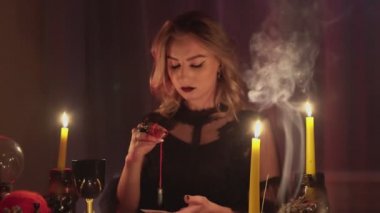 Kadın falcı kayıp kişinin fotoğrafı üzerinde sihirli bir sarkaç tutuyor.