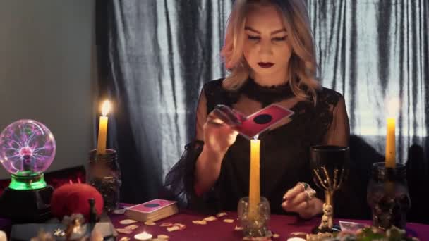 Жіночий статок, що рухає чарівну картку таро над свічкою — стокове відео