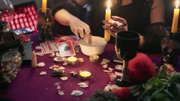 Гадалка капает воск со свечи в воду — стоковое видео