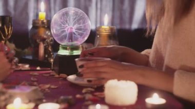 Kadın falcı kahveyi fal baktırmak için müşterisine kahve verir.