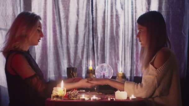 女性占い師はクライアントの手を取り、彼らは一緒に魔法のクリティカルに触れ — ストック動画