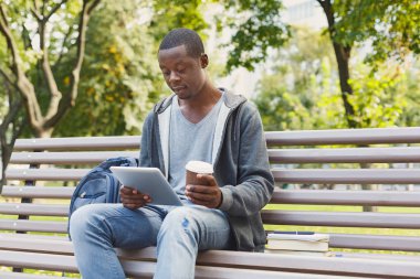 Konsantre adam açık havada onun tablet üzerinde çalışan