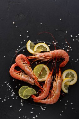 Siyah arka plan, üzerine limon ile haşlanmış karides alanı kopyalayın. En lezzetli deniz ürünleri yemek, görünüm Restoran hizmet.