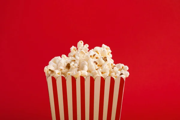 Cubo de palomitas de maíz sobre fondo rojo — Foto de Stock