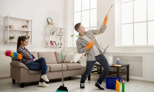 Jong koppel huis schoonmaken, spelen met mop — Stockfoto