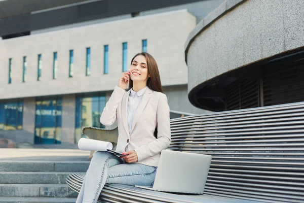 Young businesswoman working with papers outdoors