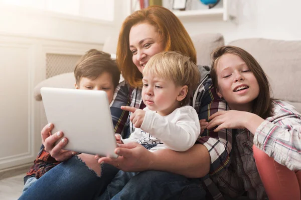 Happy mother with children using tablet together — Stock Photo, Image