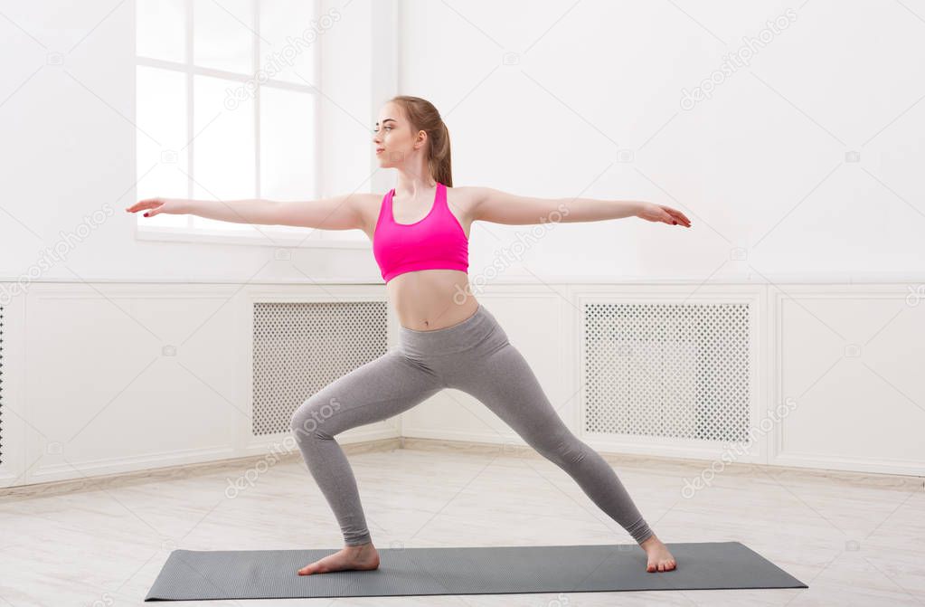 Woman training yoga in warrior pose