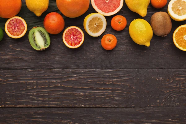 Variety of ripe citruses on wooden background