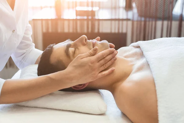 Człowiek się profesjonalny masaż twarzy w salonie spa — Zdjęcie stockowe