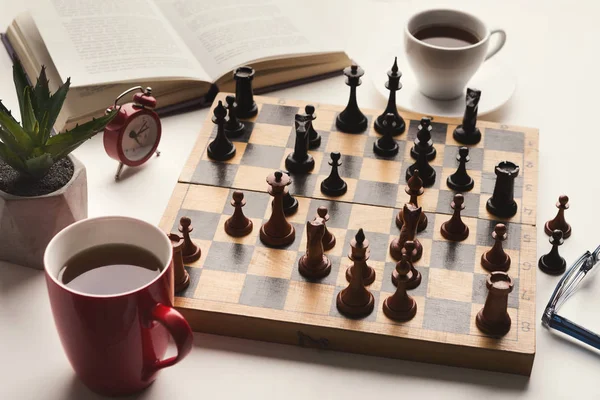 Biurko drewniane szachy grać, książki i coffee cup — Zdjęcie stockowe