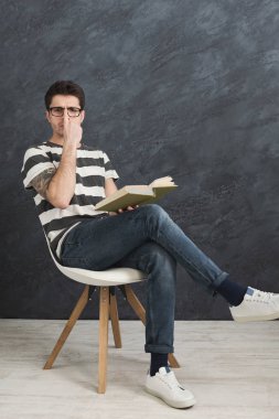 Kitap ile genç düşünceli dövmeli adam
