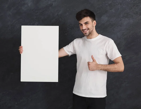 Joven hombre alegre con papel blanco en blanco —  Fotos de Stock