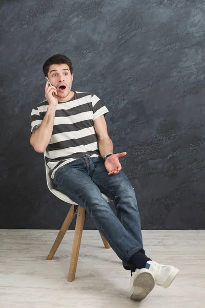 Hombre preocupado hablando por teléfono en el estudio —  Fotos de Stock