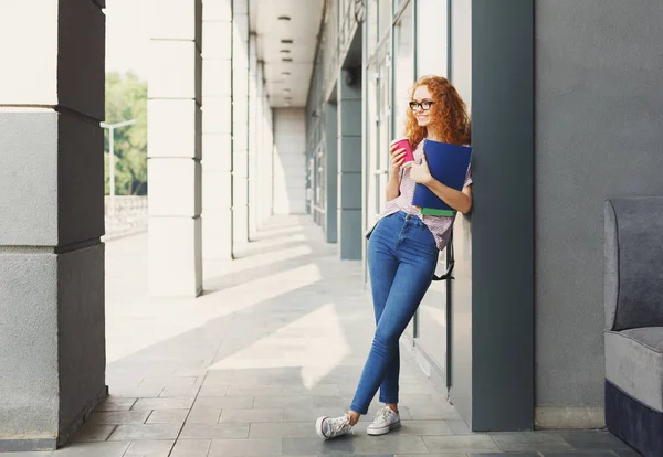 Студентська дівчина з книгами на університетському фоні — стокове фото