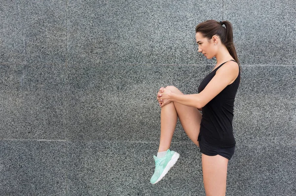 Joven corredor femenino calentándose antes de correr — Foto de Stock