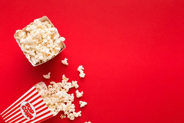 Emmer popcorn op rode achtergrond, bovenaanzicht — Stockfoto