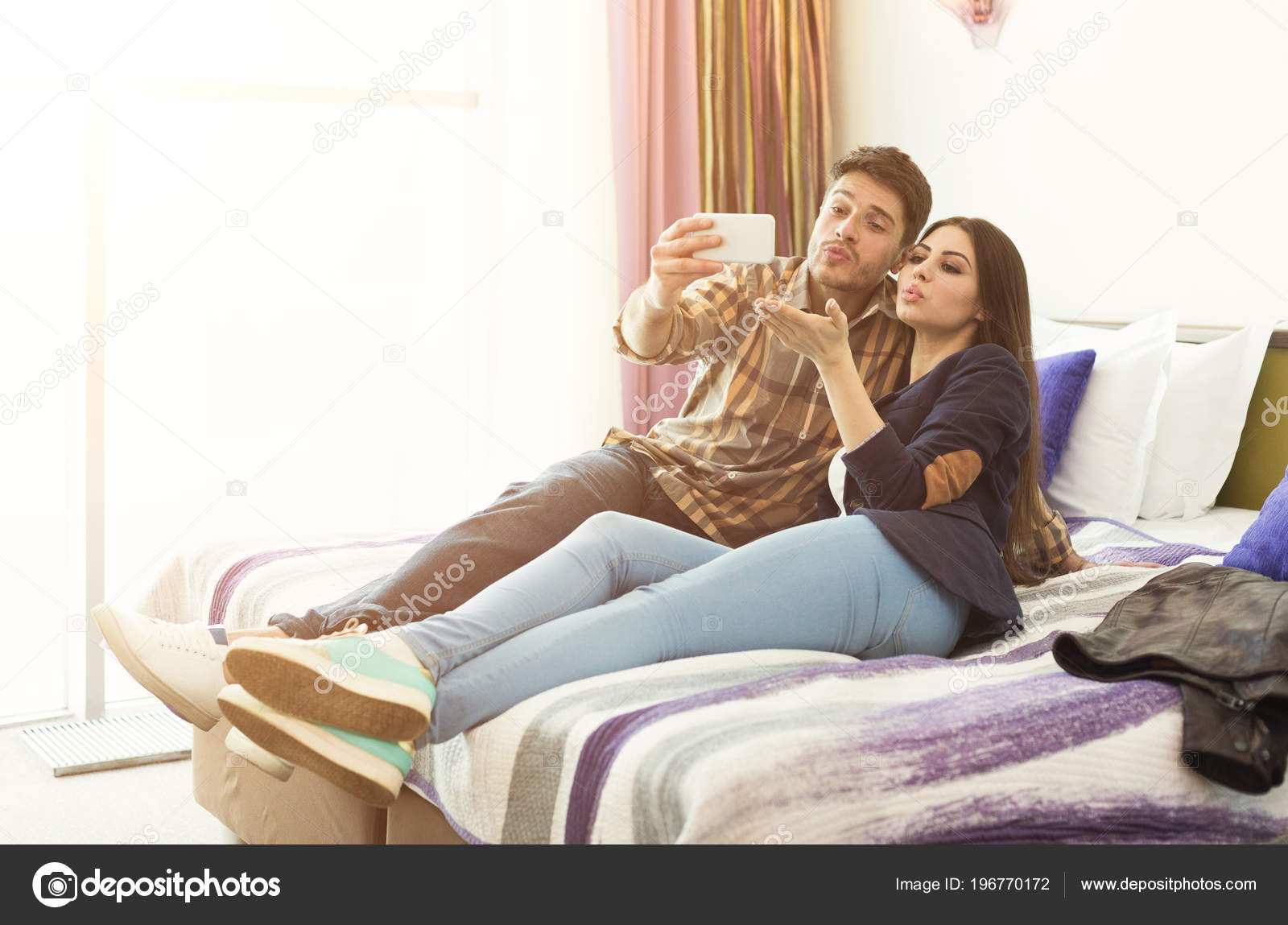 Happy Couple Rest In Hotel Room And Taking Selfie Stock