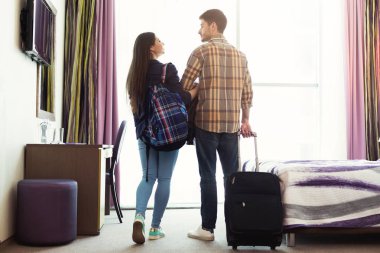 Otel odasında bagajlı genç Çift