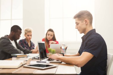 Genç adam modern ofis dizüstü bilgisayar kullanarak