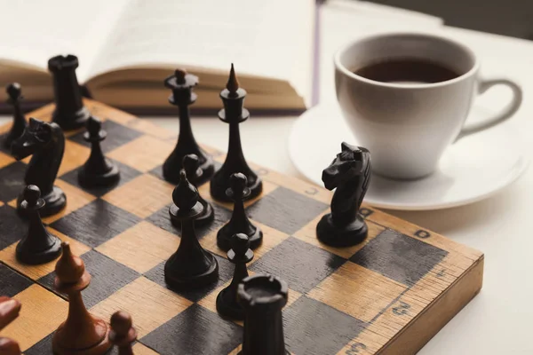 Wooden desk with chess play, book and coffee cup — Stock Photo, Image