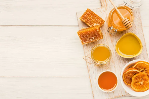 Variety of honey on white wooden planks, top view — Stock Photo, Image