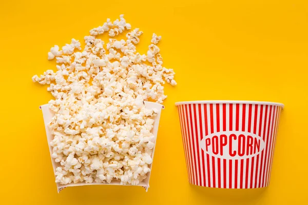 Cubo de palomitas cortado por la mitad sobre fondo amarillo — Foto de Stock