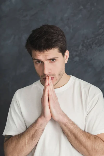 Portrait of hopeful man praying, headshot