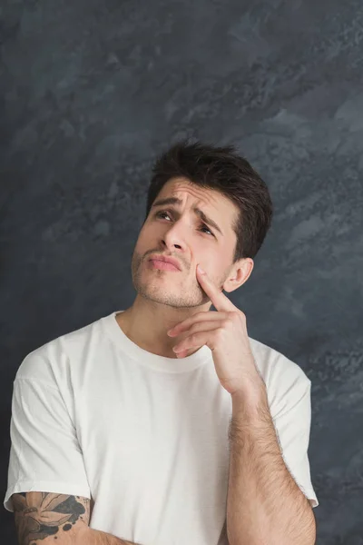 Un hombre reflexivo tocándose la barbilla, copiando espacio —  Fotos de Stock