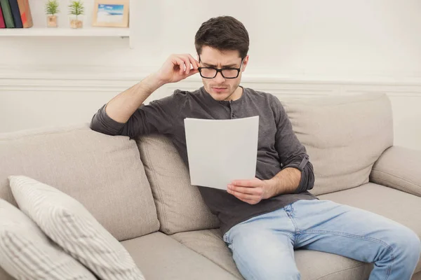 Joven hombre de negocios cansado leyendo informe en casa — Foto de Stock