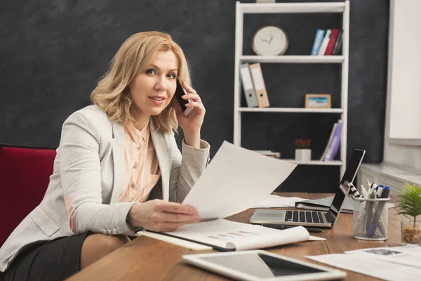 Успешная деловая женщина на работе разговаривает по телефону — стоковое фото